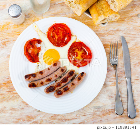 Breakfast with scrambled eggs, sausage and tomatoes Breakfast with scrambled eggs, sausage and tomatoes 119891541