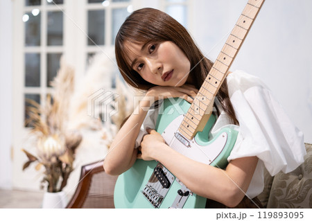 エレキギターを持つロングヘアの若い女性 119893095