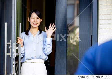玄関で手を振る夫婦 119894532