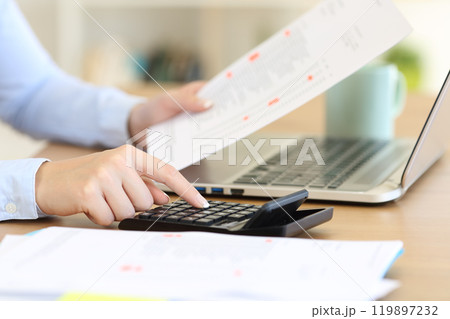 Accountant calculating with a calculator on a desk 119897232