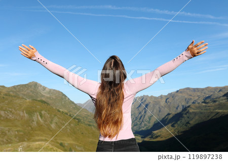 Back view of woman outstretching arms celebrating 119897238