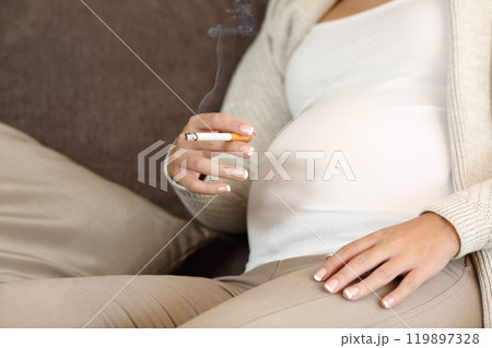 Irresponsible pregnant woman smoking a cigar Irresponsible pregnant woman smoking a cigar 119897328