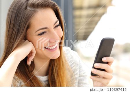 Woman browsing media in a mobile phone Woman browsing media in a mobile phone 119897413