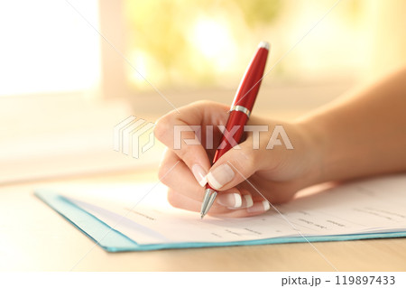 Woman hand filling form on a table 119897433