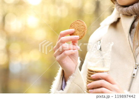 Woman hand holding a cookie ready to eat in autumn 119897442