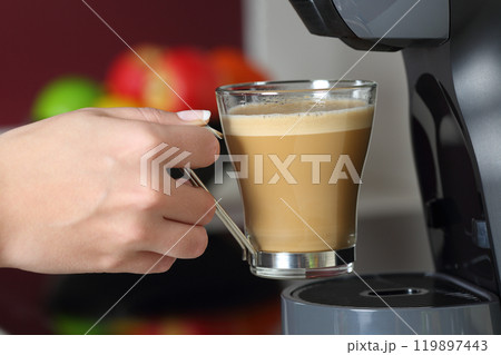 Woman hand holding a cup in a coffee maker 119897443