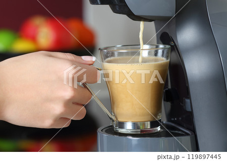 Woman hand holding a cup in a coffee maker Woman hand holding a cup in a coffee maker 119897445