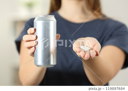 Woman hands holding a soda drink can and saccharin 119897684