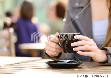 Woman holding coffee cup on her hands on a terrace 119897751