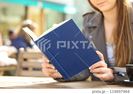 Young woman reading book on a cafe terrace Young woman reading book on a cafe terrace 119897868