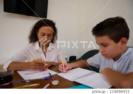 Mother and son engaged in focused study session at home Mother and son engaged in focused study session at home 119898431