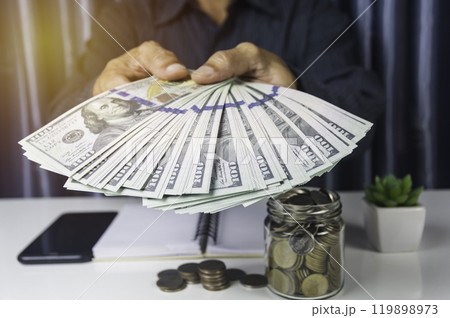 Businessman holding cash for financial income. Banknotes in hands. Hand holding out money. 119898973