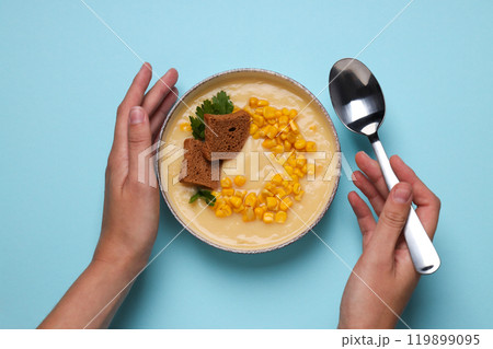 Corn soup in a plate, on a blue background. Corn soup in a plate, on a blue background. 119899095