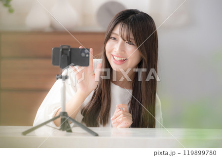 動画配信者のイメージ　かわいい若い女性がカメラに向けて手を振る 119899780