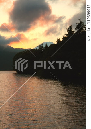 湖面を紅に染める美しい夕暮れの箱根芦ノ湖と遠く富士山の山影を見る 湖面を紅に染める美しい夕暮れの箱根芦ノ湖と遠く富士山の山影を見る 119899918