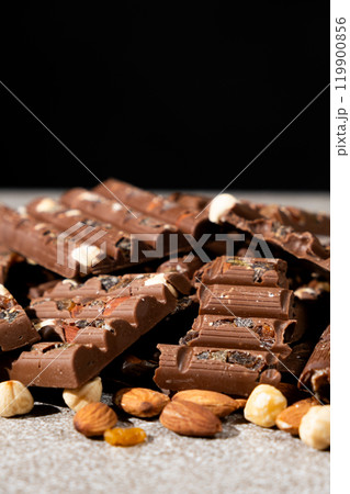 Lots of chocolate bars with nuts and raisins on a black background 119900856