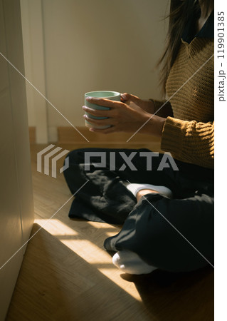 Young woman relaxing with hot drink in a serene space. Concept of relaxation and comfort Young woman relaxing with hot drink in a serene space. Concept of relaxation and comfort 119901385