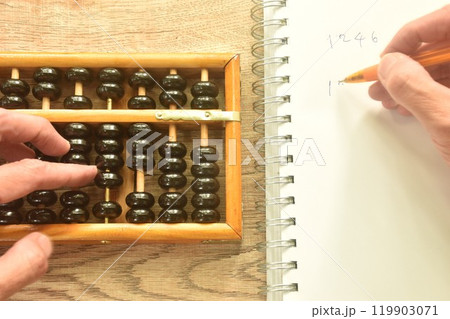 hand used wooden abacus old Chinese tool for calcuated and note in book on working desk hand used wooden abacus old Chinese tool for calcuated and note in book on working desk 119903071