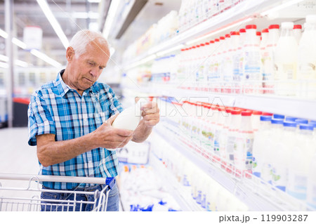 Old age man choosing milk in supermarket 119903287