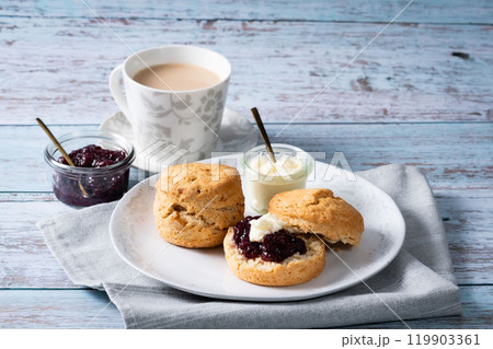 スコーンでクリームティー　アフタヌーンティー　ミルクティー　ジャムのせ　青のウッド背景2 119903361