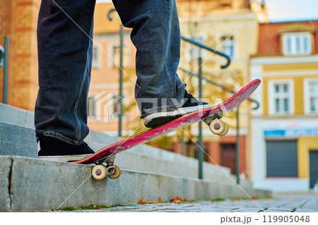 Close-up of skateboarder on pink skateboard at street Close-up of skateboarder on pink skateboard at street 119905048
