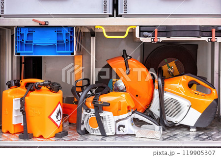 Chainsaws, fuel containers, safety gear neatly organized on metal shelf ready for professional outdoor work equipment concept 119905307