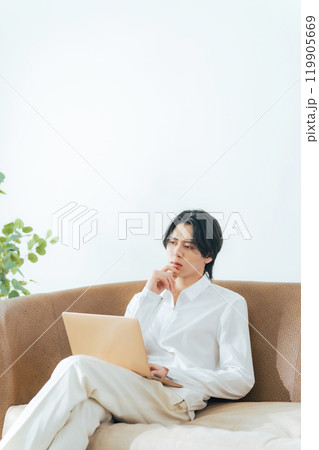 リビングでノートパソコンを使う男性 リビングでノートパソコンを使う男性 119905669