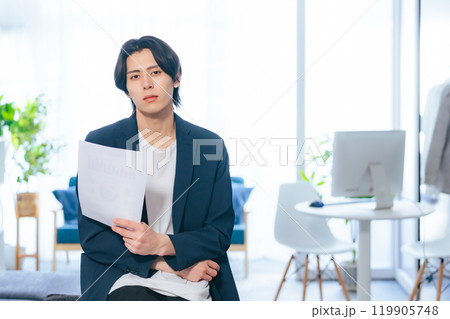 オフィスで書類を見る男性 119905748