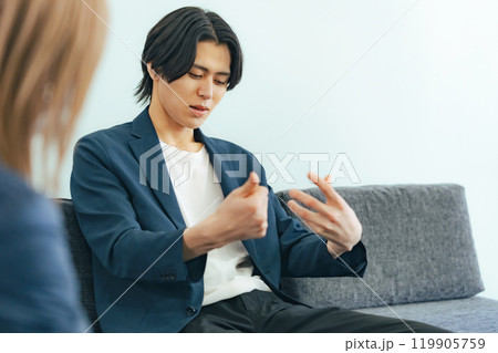 ソファに座って会話する男性 119905759