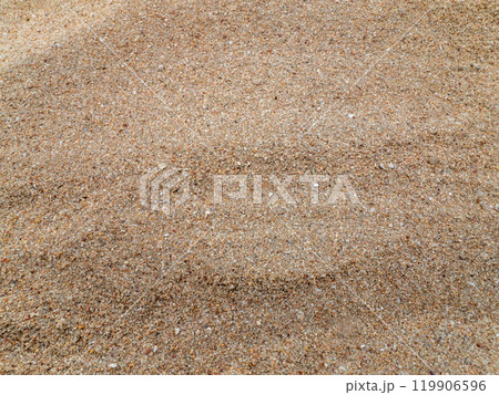 Surface of sand gravel and small fragments of broken shells on beach 119906596