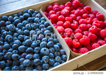 Wooden crate filled with blueberries and raspberries 119906890