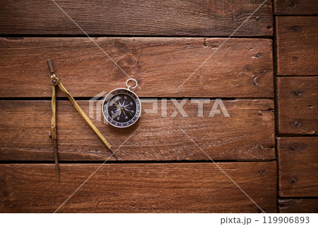 Vintage drawing and navigational Compass on a rustic wooden board Vintage drawing and navigational Compass on a rustic wooden board 119906893