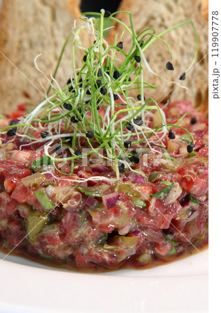 Raw meat tartare for gourmets. Raw meat tartare with spices, croutons and herbs. Beef tartare with capers. Beef tartare with bread slices. Raw meat tartare for gourmets. Raw meat tartare with spices, croutons and herbs. Beef tartare with capers. Beef tartare with bread slices. 119907778