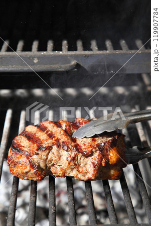 Cooking steak on the grill and coals. Roasting steak in a restaurant. 119907784