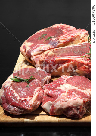 Raw aged steak. A raw, aged steak on a wooden board awaits to be cooked. 119907806