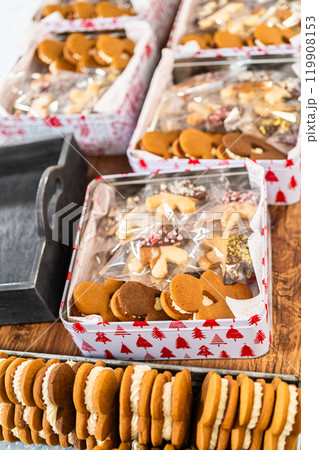 Lovingly homemade gingerbread and sugar cookies, half-dipped in rich chocolate, nestled in decorative Christmas tin boxes perfect for seasonal gifting. Lovingly homemade gingerbread and sugar cookies, half-dipped in rich chocolate, nestled in decorative Christmas tin boxes perfect for seasonal gifting. 119908153