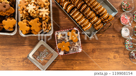 Lovingly homemade gingerbread and sugar cookies, half-dipped in rich chocolate, nestled in decorative Christmas tin boxes perfect for seasonal gifting. Lovingly homemade gingerbread and sugar cookies, half-dipped in rich chocolate, nestled in decorative Christmas tin boxes perfect for seasonal gifting. 119908154