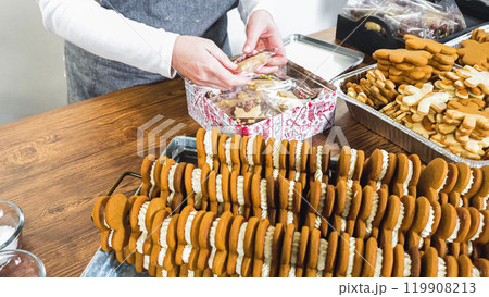 Lovingly homemade gingerbread and sugar cookies, half-dipped in rich chocolate, nestled in decorative Christmas tin boxes perfect for seasonal gifting. 119908213