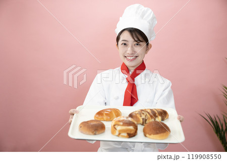 ピンクバックと焼きたてのパンを持つパン職人 119908550