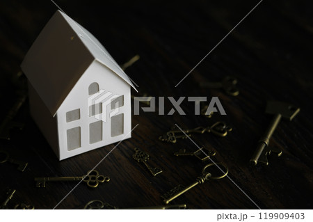 Real estate concept. Paper house and keys on a wooden background. Real estate concept. Paper house and keys on a wooden background. 119909403