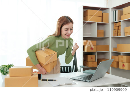 A woman is standing in a room with a laptop and boxes 119909909
