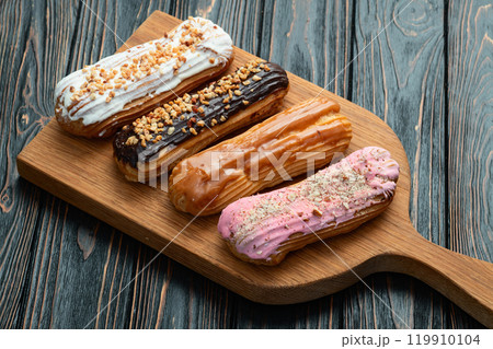 Assorted eclairs on a pastel top view Traditional French dessert 119910104