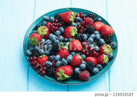 Mix of ripe colorful berries in bowl photography . Blueberry , strawberry , raspberry , blackberry and red currant . Top view 119910187