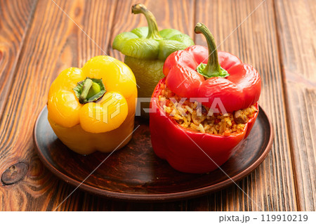 Baked stuffed pepper ( paprika ) with rice , carrot and meat . Top view on rustic background Baked stuffed pepper ( paprika ) with rice , carrot and meat . Top view on rustic background 119910219