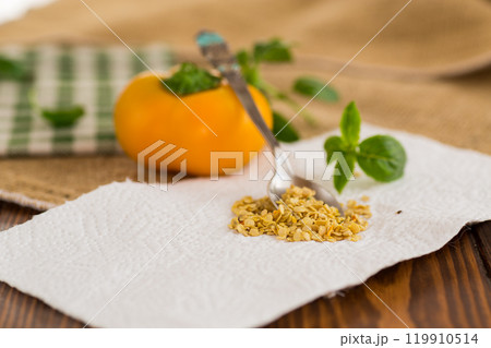 yellow pepper seeds on wooden table 119910514
