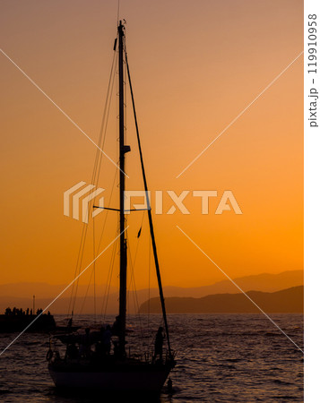 夕焼けの中のヨットのシルエット (ギリシャ、クレタ島、ハニア旧市街) 119910958