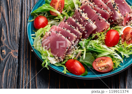 Salad with raw tuna , sesame and cherry tomatoes photography . Top view 119911374