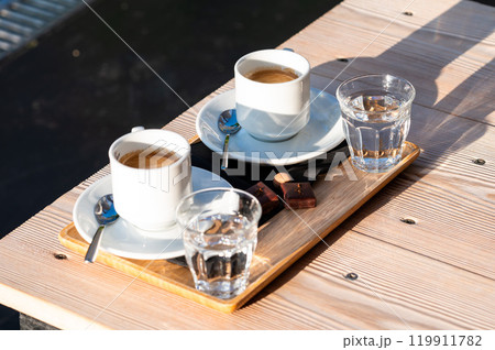 Plate with two coffees, Belgian chocolate and water in Koekelberg, Brussels, Belgium 119911782