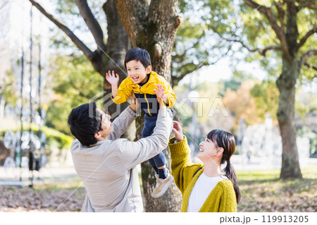 秋の公園で子供と遊ぶ家族 119913205