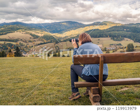 Female tourist Enjoying Scenic Mountain View With Binoculars Female tourist Enjoying Scenic Mountain View With Binoculars 119913979